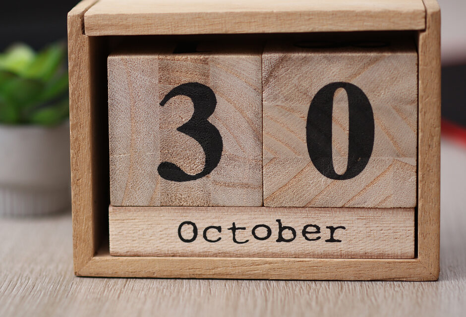 Wooden calendar with the date October 30 on desktop with laptop