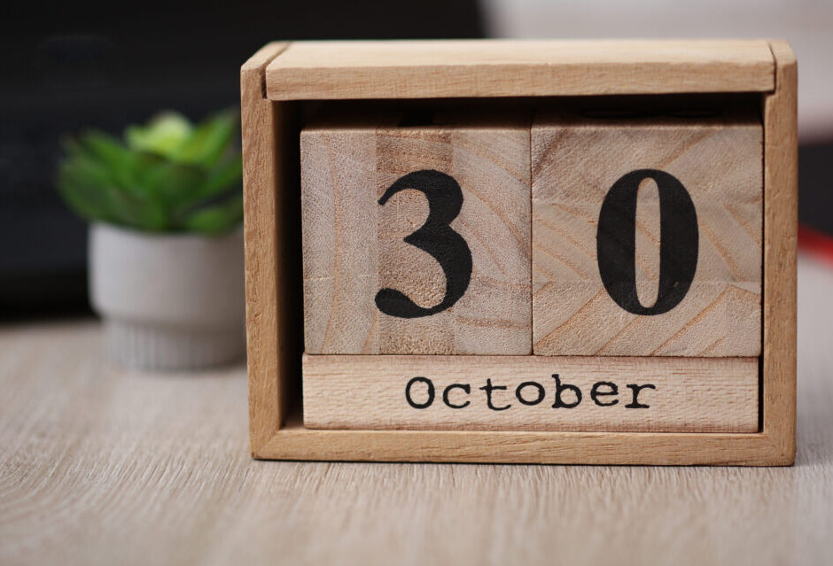 Wooden calendar with the date October 30 on desktop with laptop